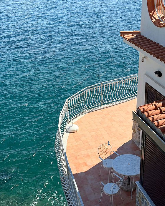 Una terrazza con ringhiera bianca sopra il mare azzurro di Cetara