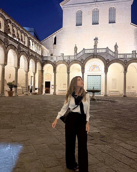 Una ragazza in piazza davanti al Duomo di Salerno illuminato la sera