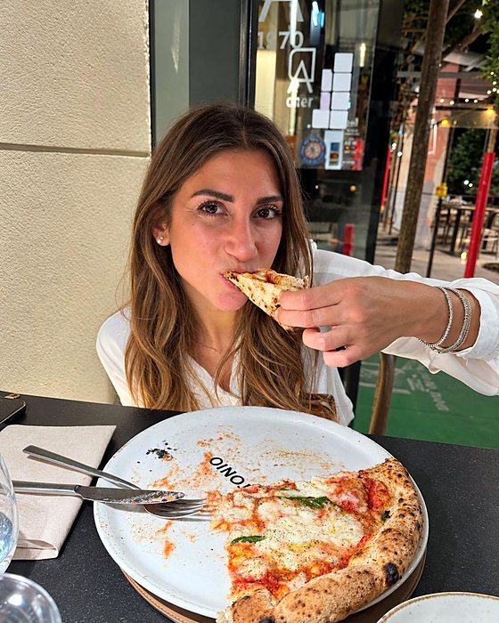 Una persona che mangia una fetta di pizza napoletana