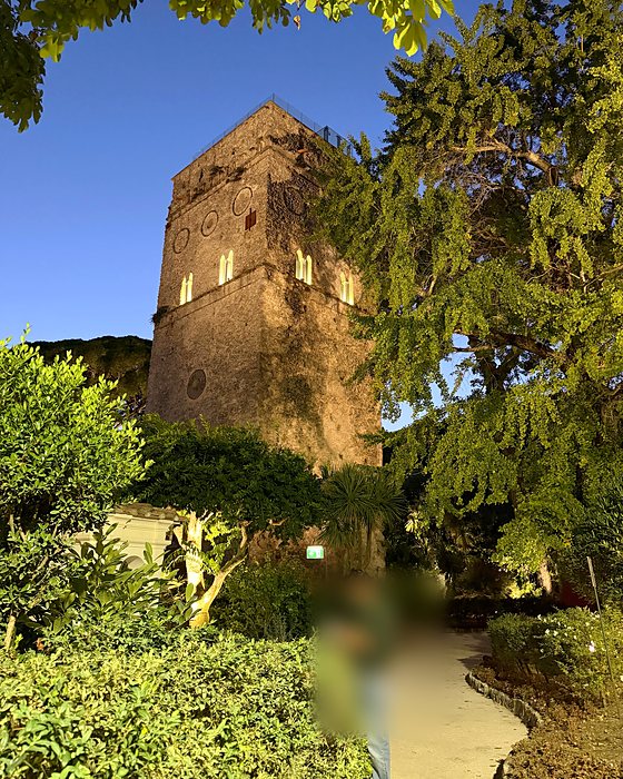 La torre di Villa Rufolo tra gli alberi, illuminata la sera