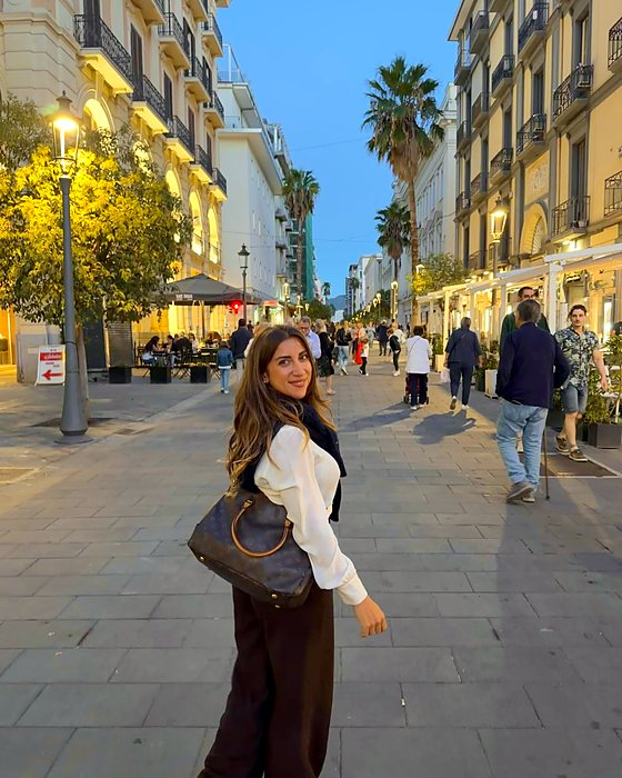Una passeggiata serale in una via di Salerno con palme e lampioni
