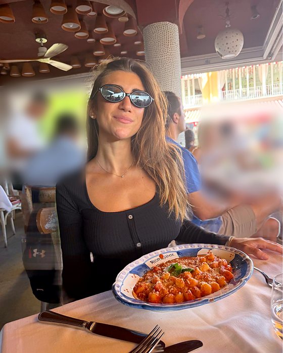 Una ragazza con un piatto di gnocchi in un ristorante di Positano