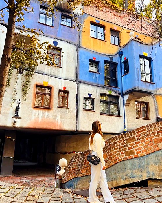 A person in front of the Hundertwasserhaus, Vienna's colourful house