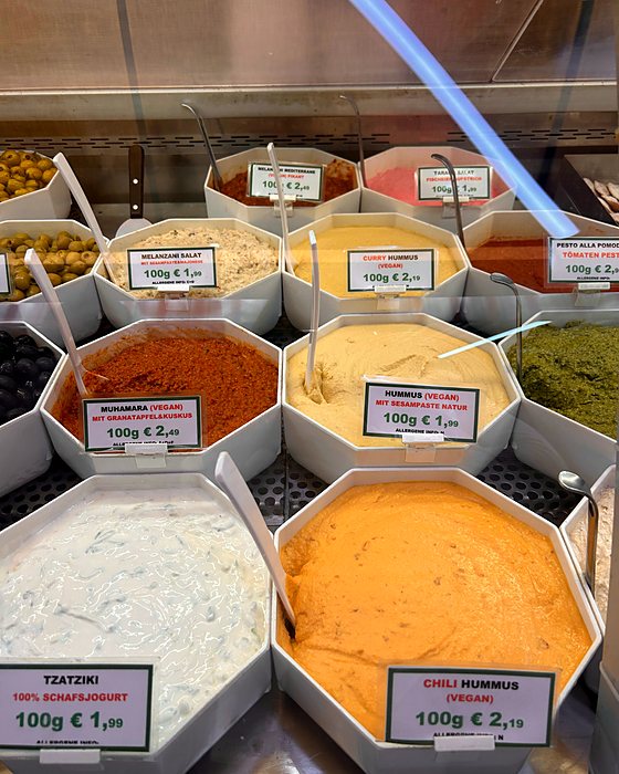 Tubs of hummus and colourful dips at the Naschmarkt, with prices per 100 g